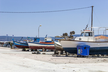 Fototapeta premium Perspective shot of back side fishing boats on ground for painting of trunk at Lesvos, Kalloni