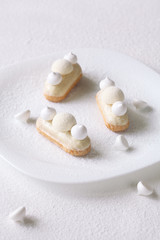 Contemporary White Chocolate and Coconut Eclairs, on white background. 
