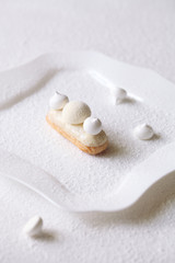 Contemporary White Chocolate and Coconut Eclairs, on white background. 
