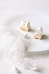 Contemporary White Chocolate and Coconut Eclairs, on white background. 
