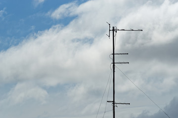 Television aerial against cloudy sky