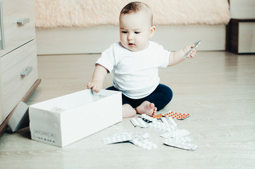 Naklejka premium baby, girl sitting on the floor in the hands of pills