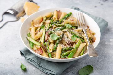 asparagus and bacon penne pasta with parmesan cheese in white bowl
