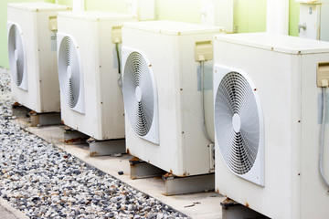 Air-conditioned cabinets with fan placed outside the building are lined up.