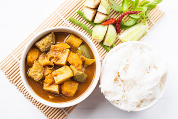 Fish organs sour soup (Kaeng Tai Pla) in a bowl with rice noodles and vegetables, top view, Southern Thai food
