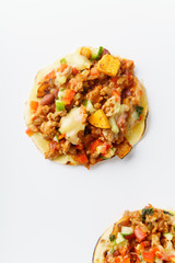 Close up of mexican taco with chili con carne, grilled sweet potatoes and grated cheese on white background. Text space