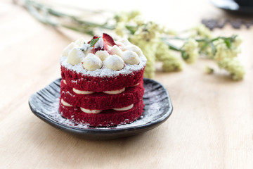 Thai Cake. Velvet red cake. Cookies icing and Strawberry decorated with red cake on wooden table and flower.