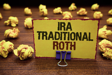 Handwriting text writing Ira Traditional Roth. Concept meaning are tax deductible on both state and federal Yellow sticky card clipped text notice crumpled paper balls wood table.