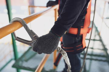 Working at height equipment. Fall arrestor device for worker with hooks for safety body harness on selective focus.