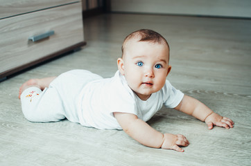 Fototapeta premium Beautiful baby in the interior. Baby crawling on the floor.