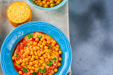 Hummus and tahini with olive oil, pepper, Chickpea, parsley, spices served in a cracker on a modern trendy background.Hummus Traditional Middle Eastern food. Copy space for text.