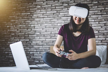Fototapeta na wymiar Young woman have fun in virtual reality headset or 3d glasses playing video game, gaming and technology concept