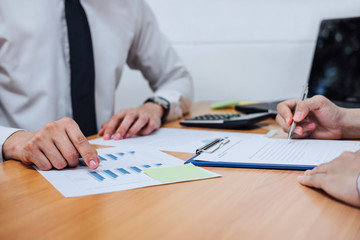 Two business team working and discussing Financial investment on report with calculate Analyze business and market growth on financial document data graph and digital tablet