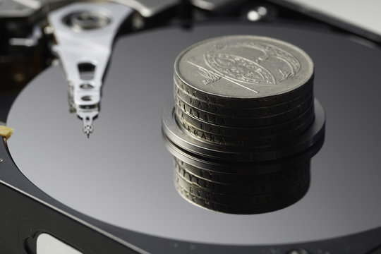 stack of coins on a hard disk - Powered by Adobe