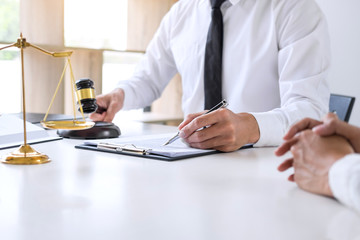 Businesspeople or lawyer having team meeting discussing agreement contract documents, judge gavel with Justice lawyers at law firm in background, Legal law, advice and justice concept