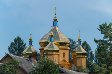 golden domes with crosses of a wooden church