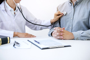 Female doctor checking heart beat of patient and recommend treatment methods and how to use medicine