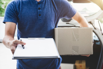 Home delivery service and working with service mind, deliveryman with boxes standing by in front of the customer house doors and holding clipboard
