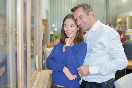 adult happy couple looking at bathroom tile in furniture store