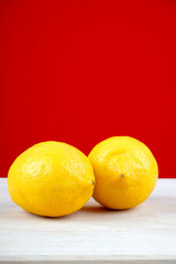 Lemon on a wooden table over red background