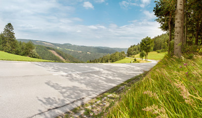 Steile Bergstraße bei trockener Fahrbahn im Sommer ohne Verkehr