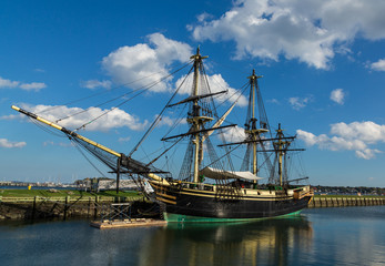 Sailing ship at the pier with cloudy blue sky