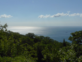 Obraz premium A magnificent landscape stretching away to the horizon line of the sea with a blue sky on it and rare clouds and an iodine boat sailing along the shore.