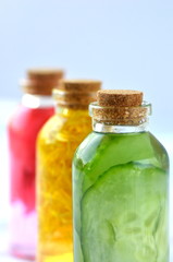 Three glass vial bottles of fresh natural plant based skin care facial toners with copy space. Organic herbal, plant and flower infusions for face and body. Cucumber, marigold and rose.
