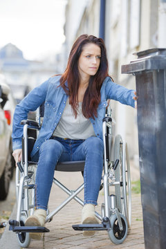 Woman in wheelchair struggling to pass obstruction