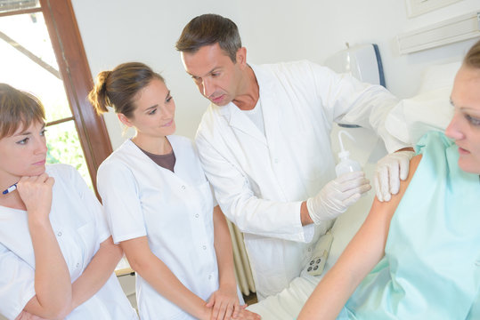 Doctor holding liquid and patient's arm