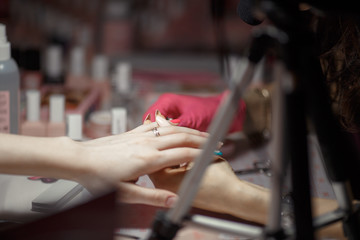 paiting women nails in pink gloves on light background
