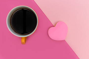 Coffee cup and love heart on pink background