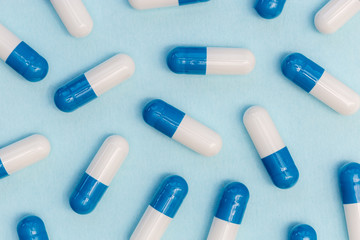Drugs pills capsules on blue background abstract concept