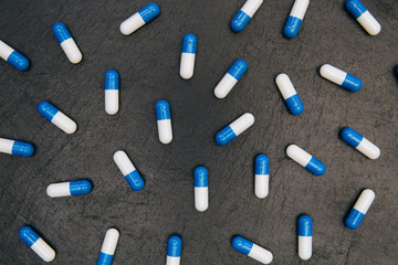 Drugs pills capsules on dark background abstract concept