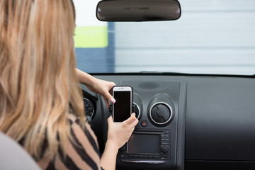 teenager with cellphone inside car