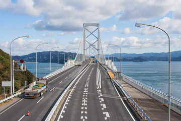 Fototapeta na wymiar Great Naruto bridge cross over ocean. It is a large suspension bridge that stretches across the Naruto Strait connecting Awaji city in Hyogo and Naruto Town in Naruto city. Japan.