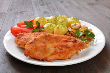 filety z kurczaka z ziemniakami surówką i pomidorem