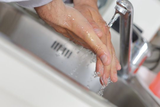 washing hands with streaming water in bathroom hygiene