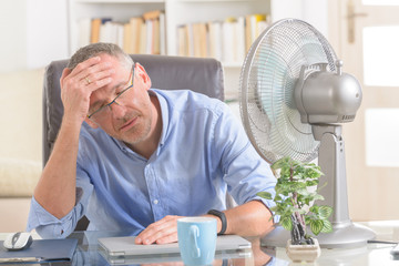 Man suffers from heat in the office or at home