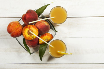 Peach fresh juice with fresh peaches on a white background. Top view, copy space. Fresh juice with peach. Healthy eating.
