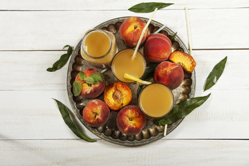 Peach fresh juice with fresh peaches on a white background. Top view, copy space. Fresh juice with peach. Healthy eating.
