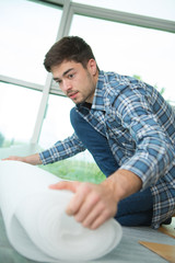 young man sitting on floor assembling flatpack closet