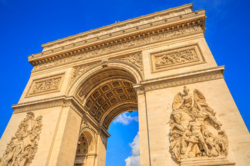 Fototapeta na wymiar Bottom view of Arch of Triumph at center of Place Charles de Gaulle in a beautiful sunny day with blue sky. Popular landmark and famous tourist attraction in Paris capital of France in Europe.