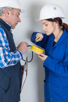 electrician explaining to apprentice