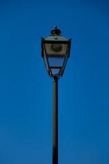 Fototapeta na wymiar vintage dark green street lamp with a blue sky background