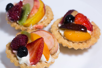 Fruit tart with custard cream and fresh blueberry, strawberry, raspberry, peach and kiwi.