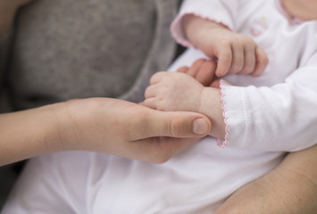 Mother holding baby's hand