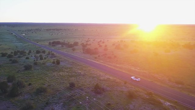 Cabrio car driving in the sunset on an open road in the middle of nowhere