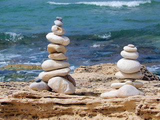 Fototapeta na wymiar Figures on the sea coast, built of stones by people.