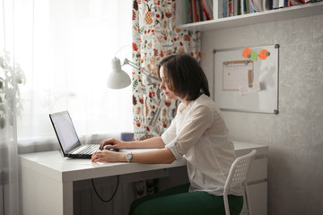 tired serious woman working at a computer at home